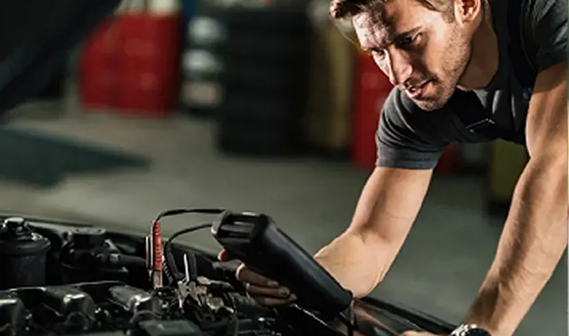 Técnico verificando o motor de um carro durante a revisão